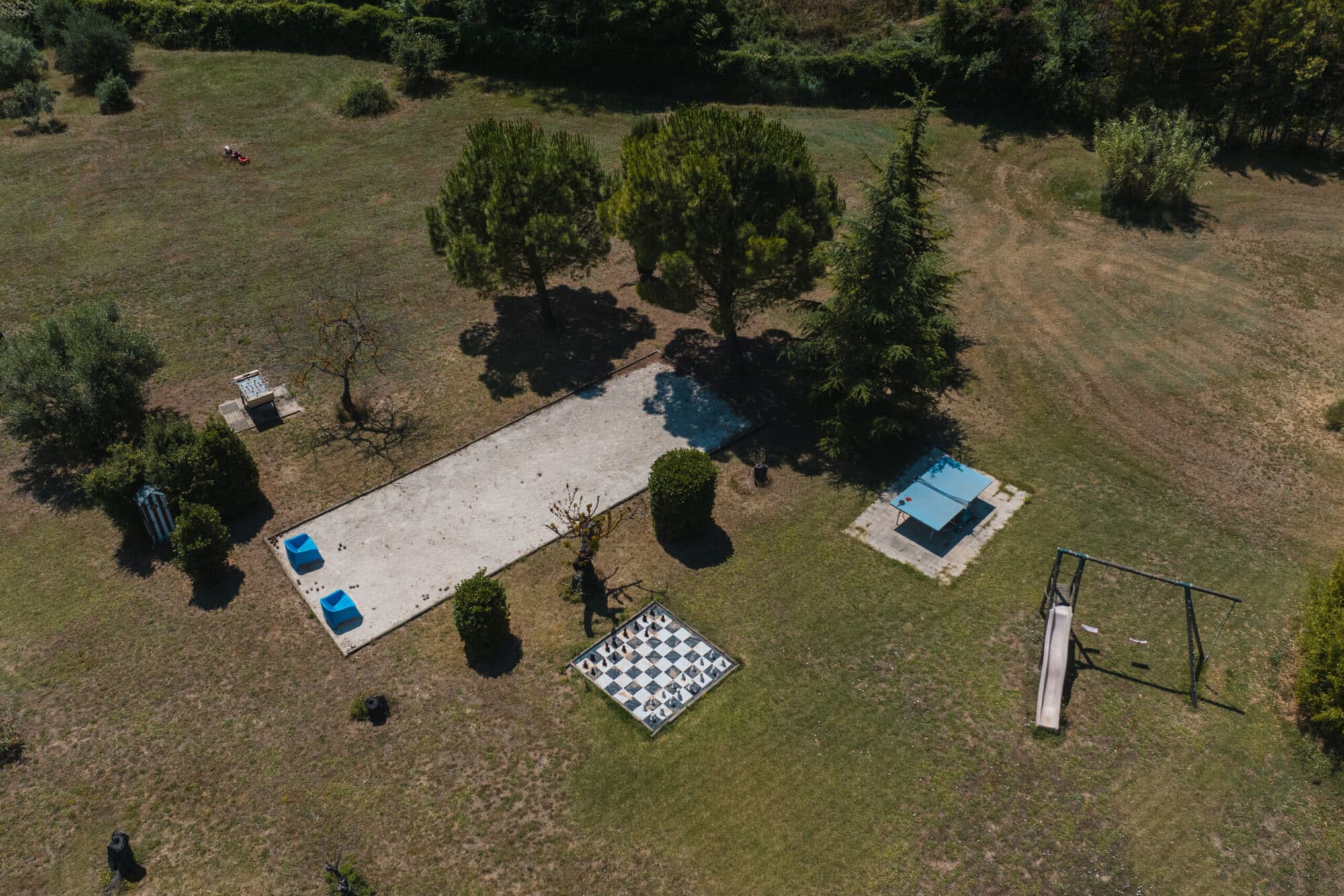 Vue aérienne du jardin avec la piscine, des arbres et une terrasse, en Luberon